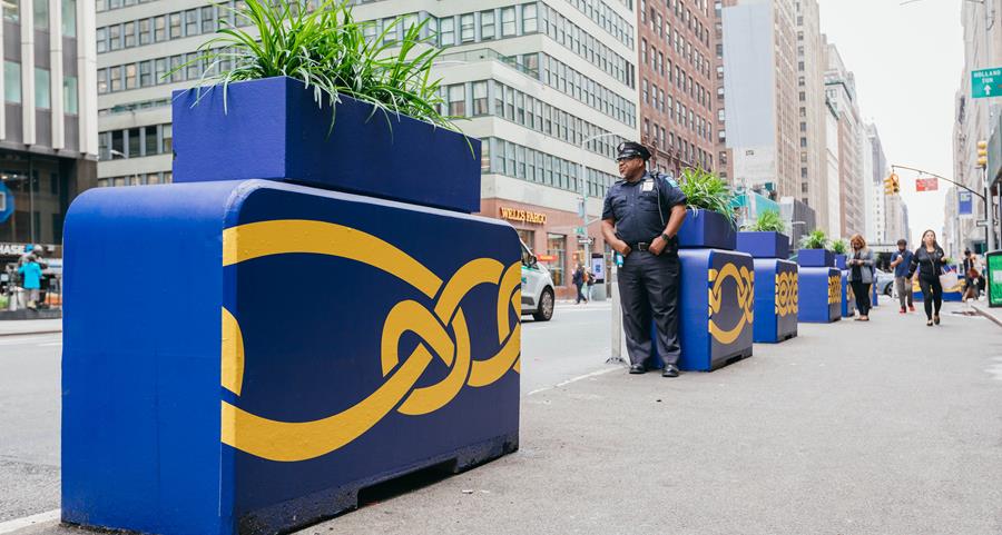 A twisting yellow knot painted across blue traffic barriers