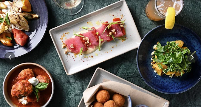 Multiple plates of various good including ceviche, salad, meatballs and more