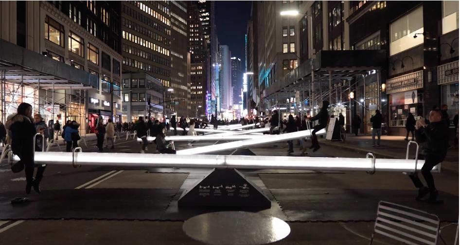Image of people atop a row of lighted see-saws