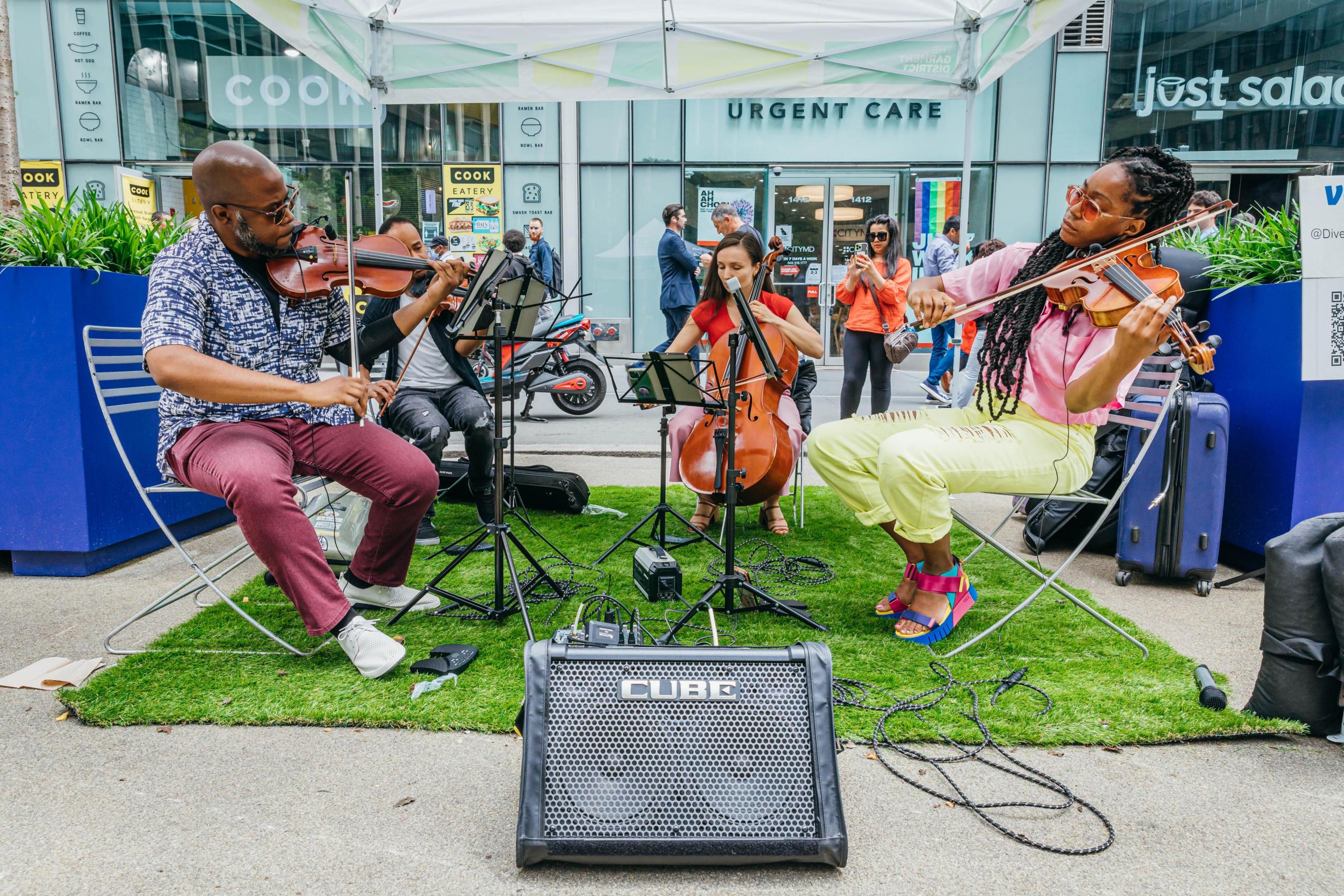 A quartet of string musicians playing under a tent