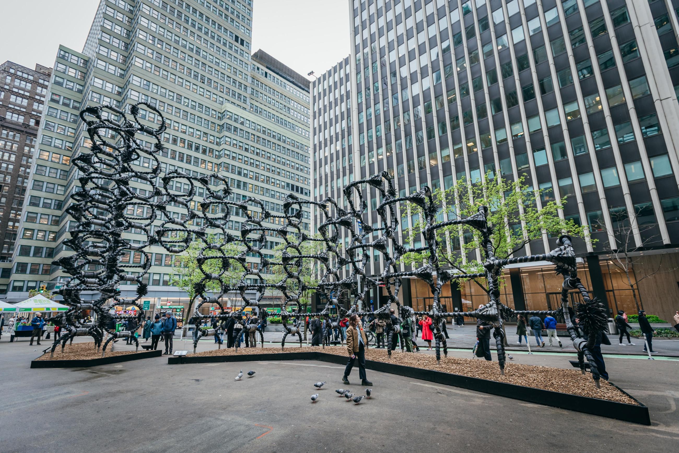 A large geometric structure made of  a latticework of interconnected steel bars wrapped artistically with strips of old tires. 