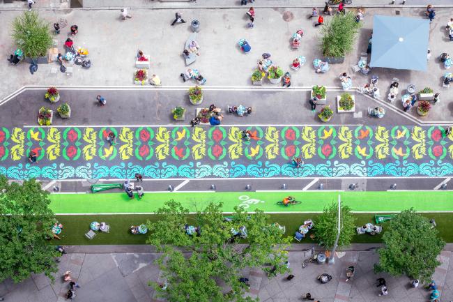 Overhead view of brightly-colored urban garden painted on the street. 