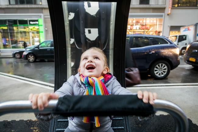 Close-up image of child sitting inside a LOOP looking up at the display above.