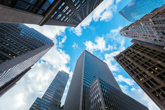 View from the ground, straight up at sky with skyscrapers around the perimeter