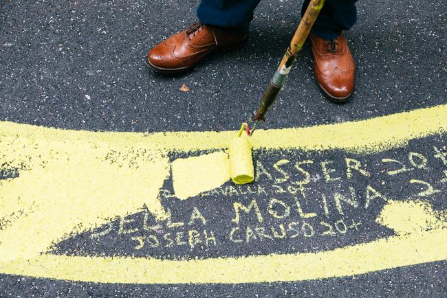 Detail of the mural - a section with names being painted over in yellow