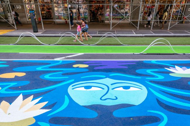 Close up of a section of the mural includes a face and water lily.