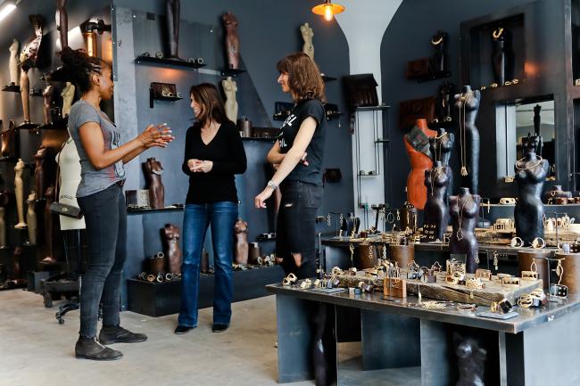 Three people standing in a circle in an accessories shop