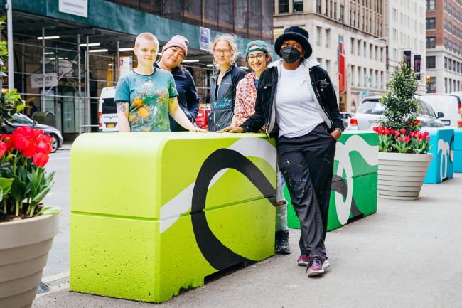 A group of people standing around a bright green colored cube.