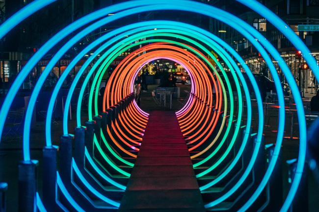 A woman entering a tunnel of colorful rings