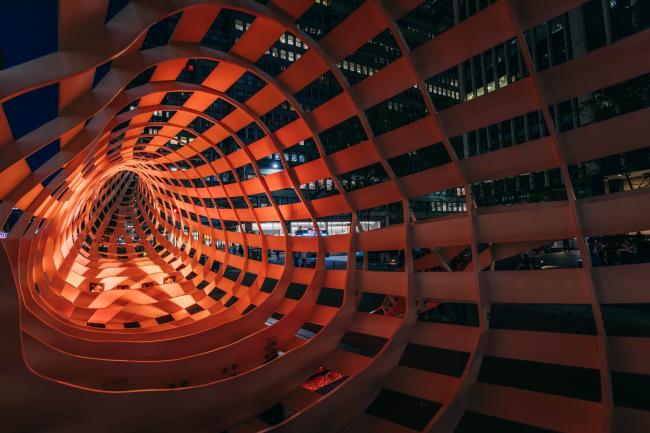 A view inside the belly of the mesh steel whale, illuminated in orange light.