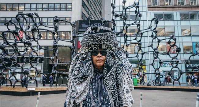 Artist Chakaia Booker standing in front of Shaved portions. 