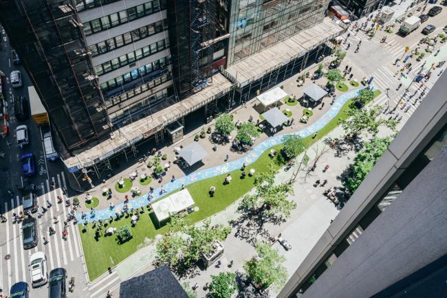 a view from above showing the full  length of the block long blue mural in the middle of one block of Broadway. 