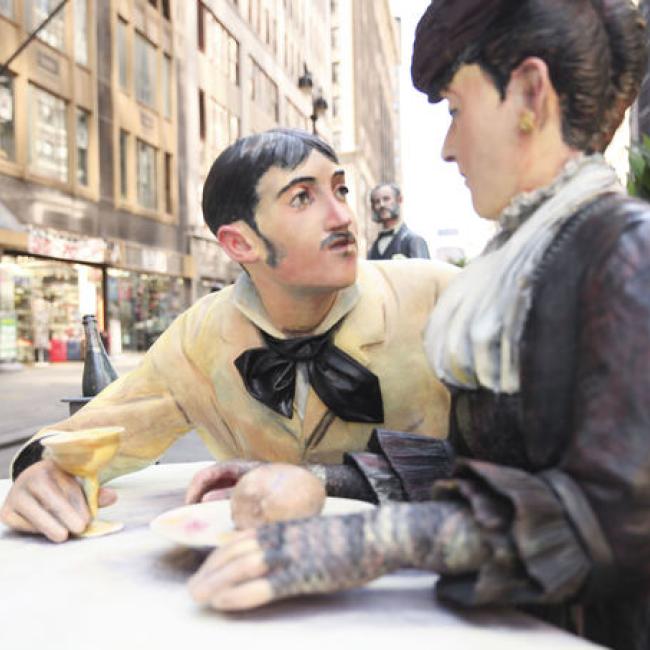 Sculpture of a couple sitting at a table