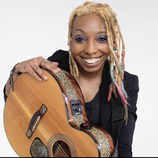 Chanese Elifie posing with a guitar. 